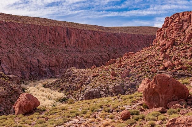 Arid desert terrain around San Pedro de Atacama in northern Chile, with dry rocky ground and bare mountain ridges under a wide open sky